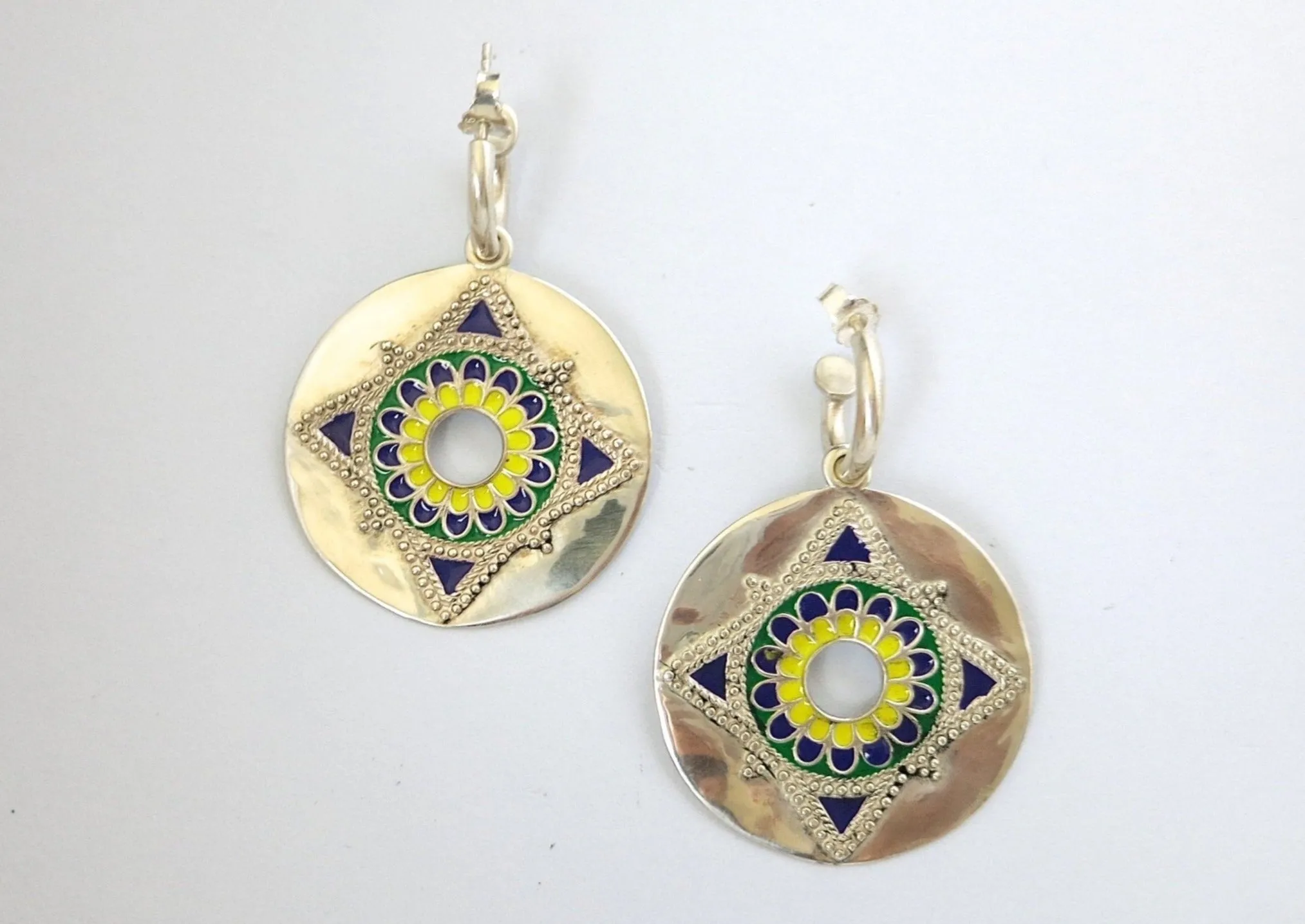 Show-stopping earrings with a dangling enamel disc on small open hoop